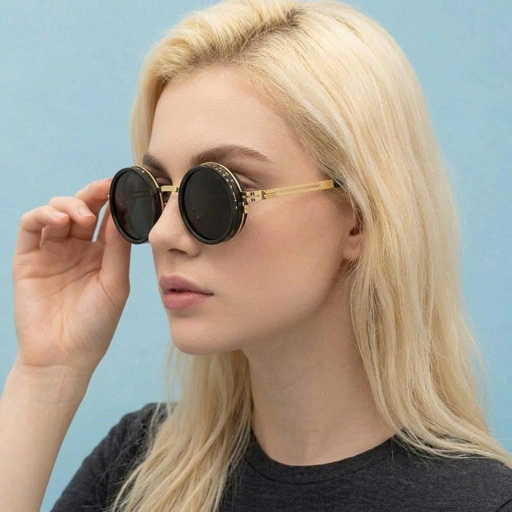 Woman wearing round sunglasses against a light blue background